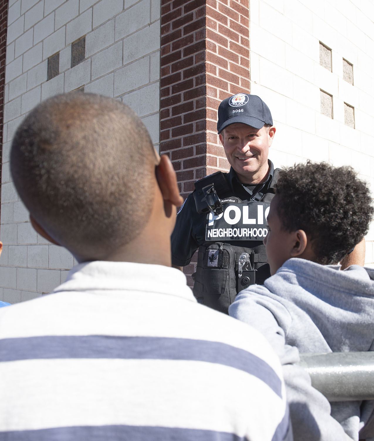 TPS officer with two young boys seen from behind